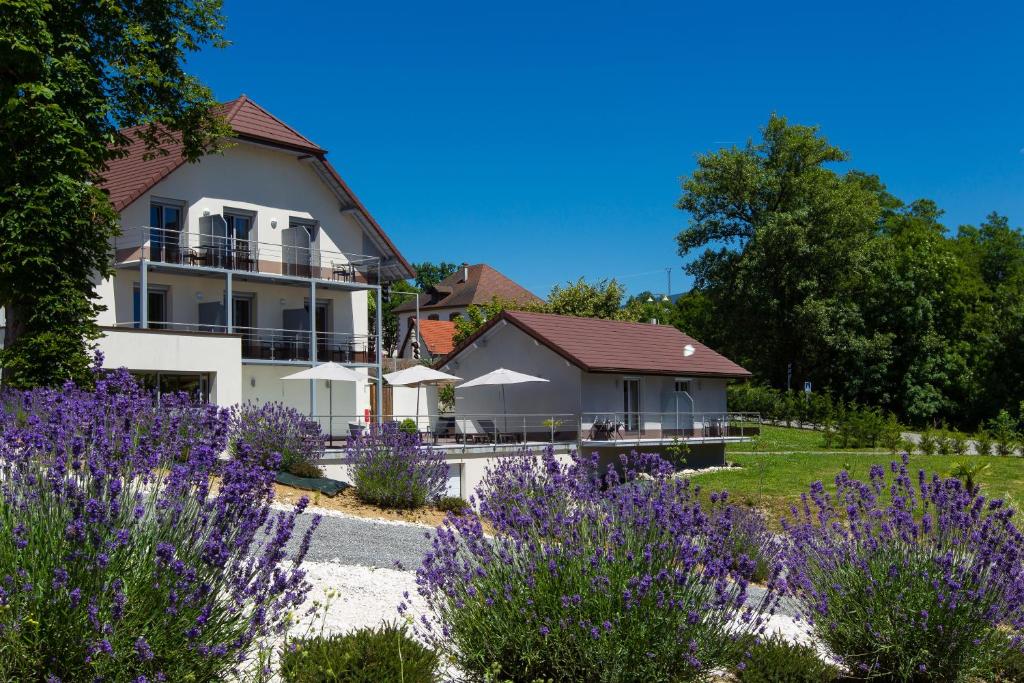una casa con flores púrpuras delante de ella en Hotel Blanc, en Marigny-Saint-Marcel