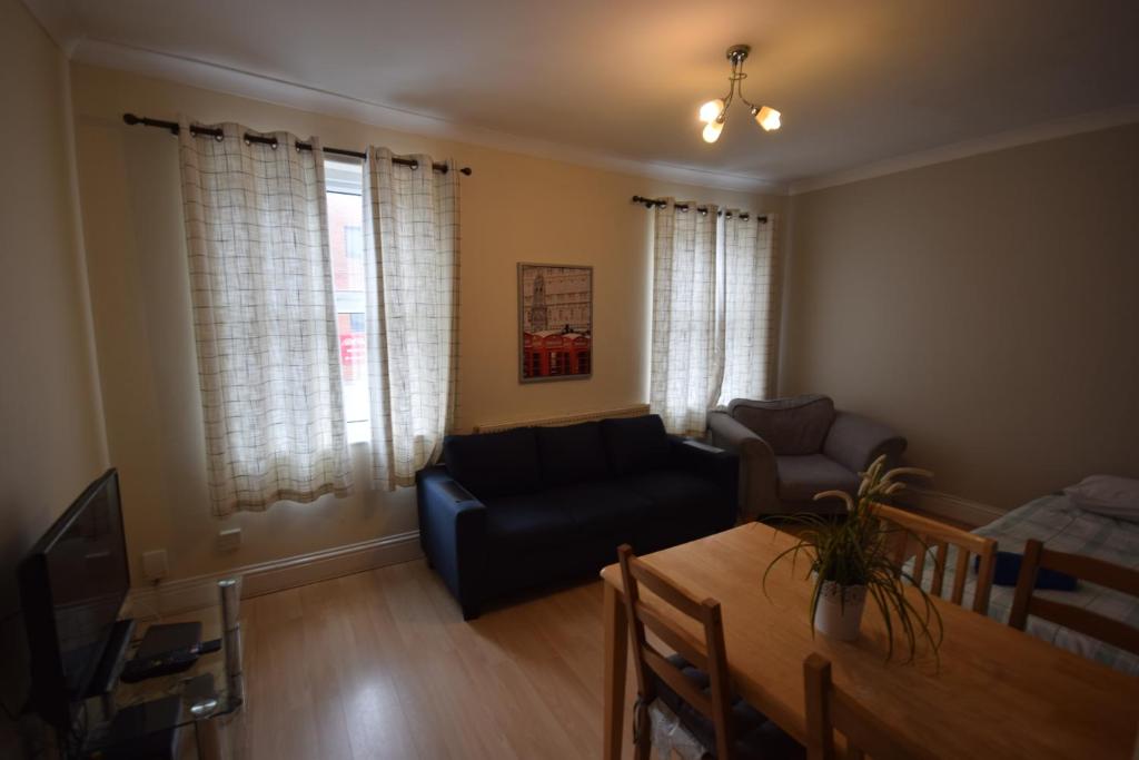 a living room with a couch and a table at Two Bedroom Flat St Andrews Road in London