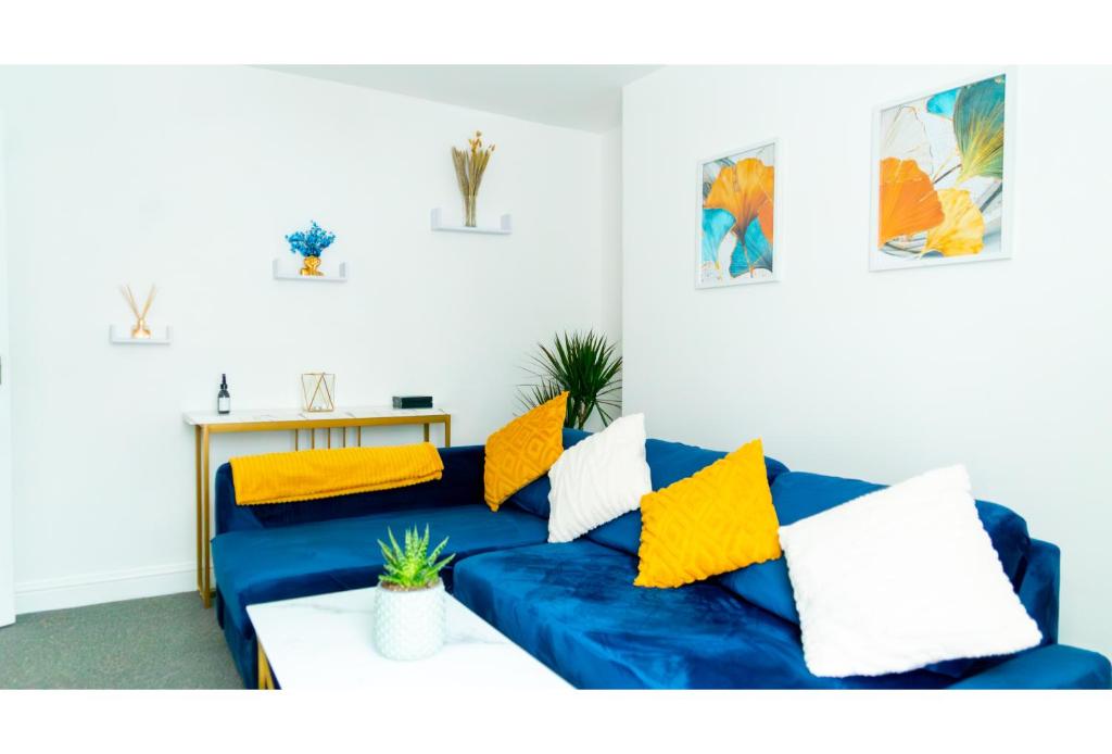un sofá azul con almohadas amarillas en la sala de estar. en Clifton’s Cosy Escape en Bristol