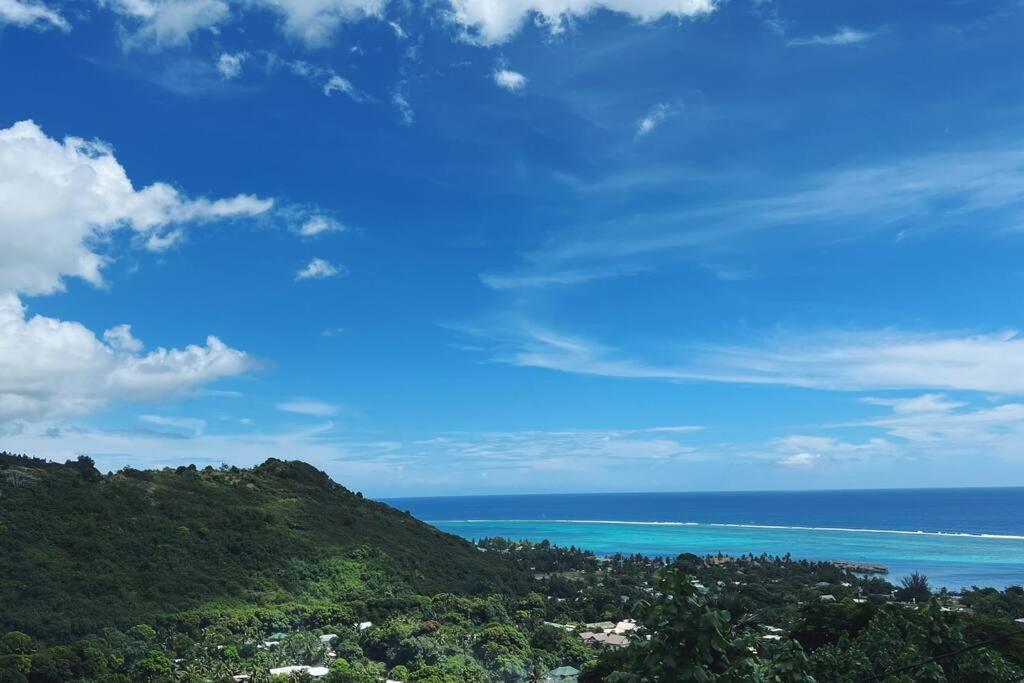 - une vue sur l'océan depuis une colline avec un ciel bleu dans l'établissement MOOREA Bungalow Kohimana avec vue lagon, à Moorea