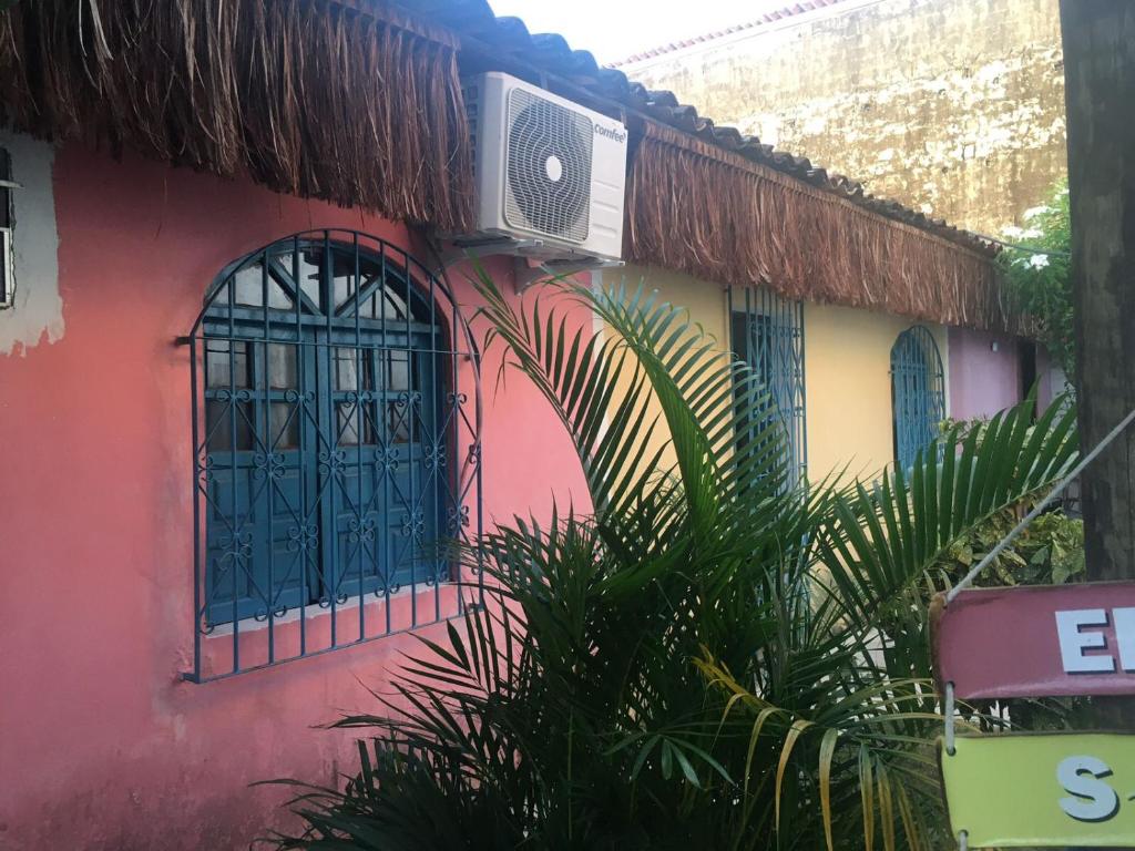 a colorful building with windows and plants in front of it at Hostel Itaparica in Itaparica Town