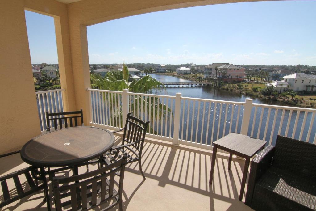 einen Balkon mit einem Tisch und Stühlen sowie Flussblick in der Unterkunft Come stroll along the beach and enjoy shared resort style amenities! in Palm Coast