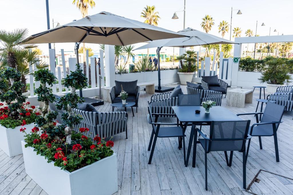 a patio with tables and chairs and an umbrella at EUROPA Hotel in Vasto