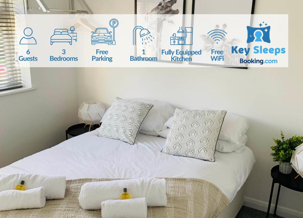 un letto con lenzuola e cuscini bianchi in una stanza di Spacious House, Free Parking & Patio Garden a Farnham