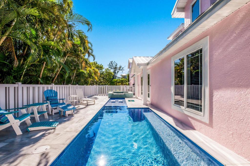 a swimming pool next to a pink house at Little Pink Houses in Anna Maria