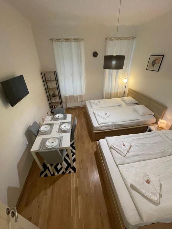 een kleine kamer met drie bedden en een televisie bij Cozy 5-Person apartment in Vienna 2 in Wenen