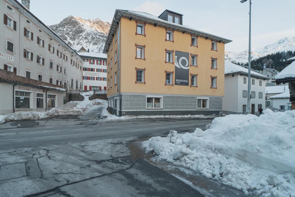 a building on a street covered in snow at Brocco e Posta Lodge in San Bernardino