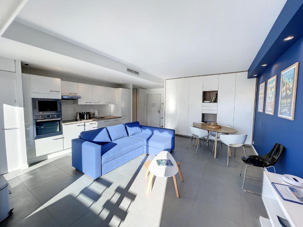 un salon avec un canapé bleu et une table dans l'établissement Stunning 1 BR 3 pers Résidence Cannes Suquet Vieux Port Croisette 1 mn by Olam Properties, à Cannes