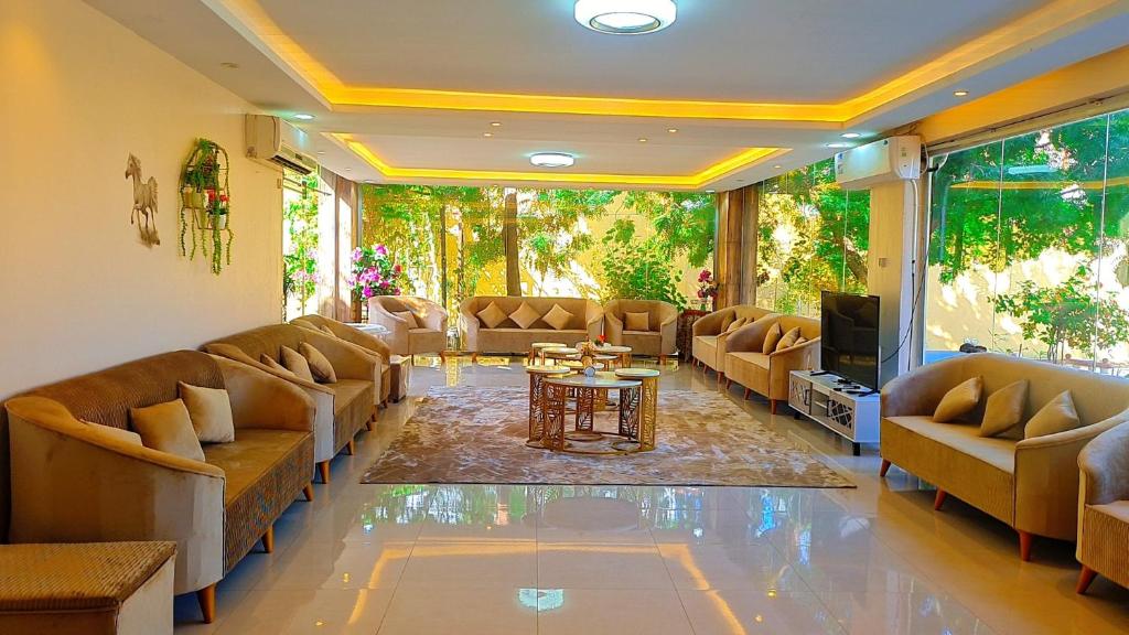 sala de estar con sofás, TV y mesa en شاليهات الدرب منتجع ليله en Qarār