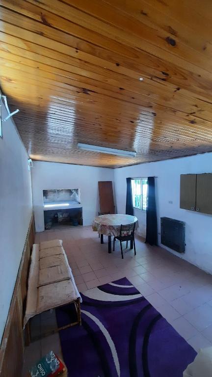 a living room with a wooden ceiling and a table at Cumbre House in Malargüe