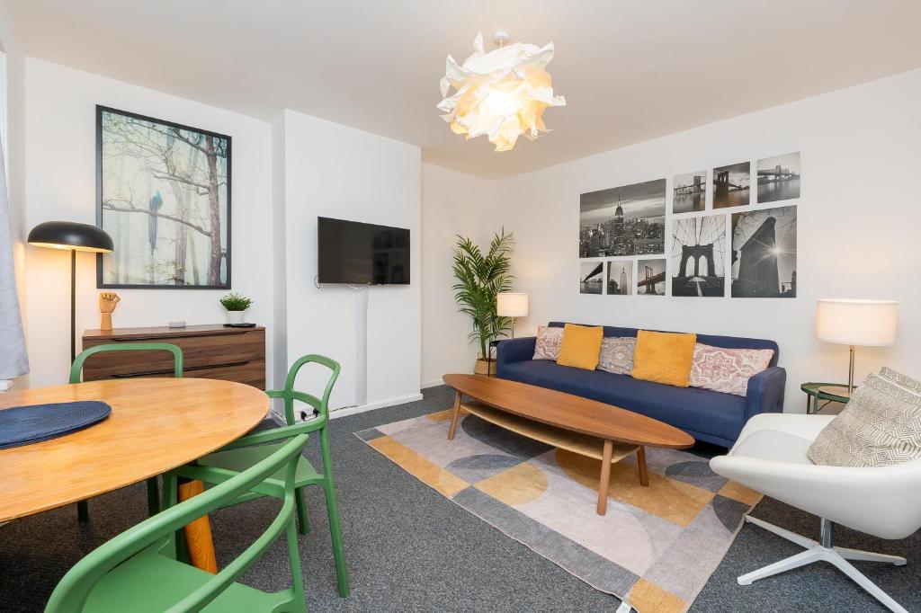 uma sala de estar com um sofá azul e uma mesa em Brett Stays - Middleton Oasis em Avonmouth