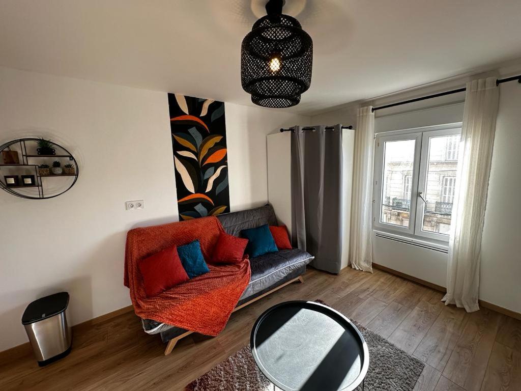 ein Wohnzimmer mit einem Sofa und einem Spiegel in der Unterkunft Le Songe bleu - centre ville - netflix in Niort