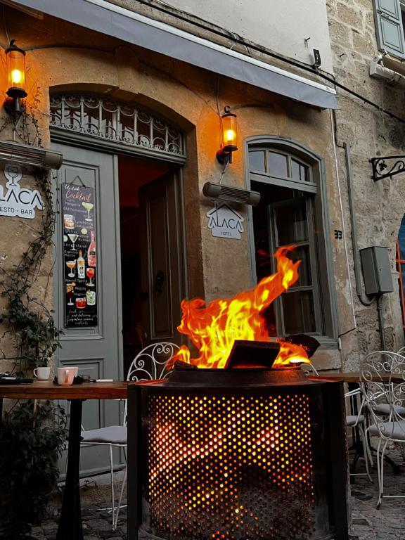 a fire pit in front of a restaurant at Alaca Butik Otel in Cesme