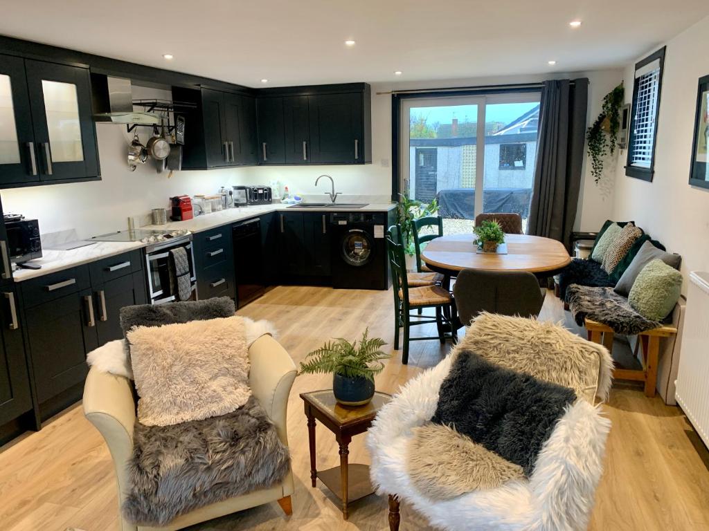 a kitchen with black cabinets and a table and chairs at The House of Golf in Fife