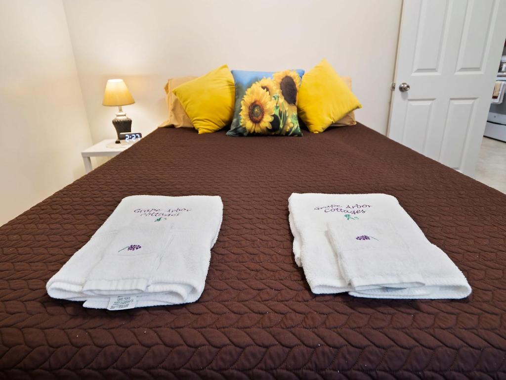 ein Bett mit zwei weißen Handtüchern darüber in der Unterkunft The Riesling Cottage - GOTL Strip - Cozy & Quaint in Geneva
