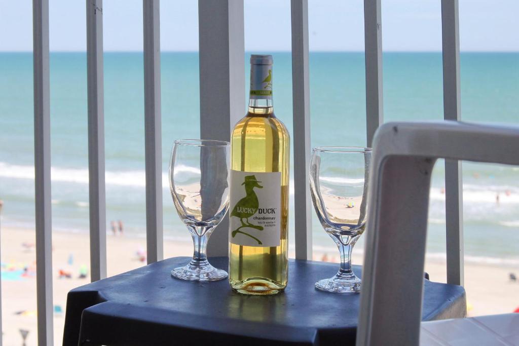a bottle of wine and two wine glasses on a table at 2501 S Ocean Blvd, 0505 - Ocean Front Sleeps 6 in Myrtle Beach