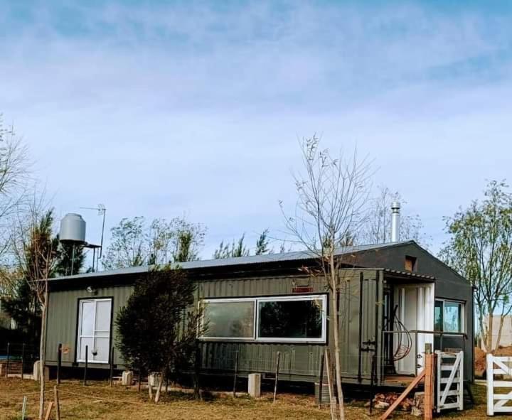 einem grünen Wohnwagen auf einem Feld mit Bäumen in der Unterkunft Alojamiento con pileta en Cañuelas in Cañuelas