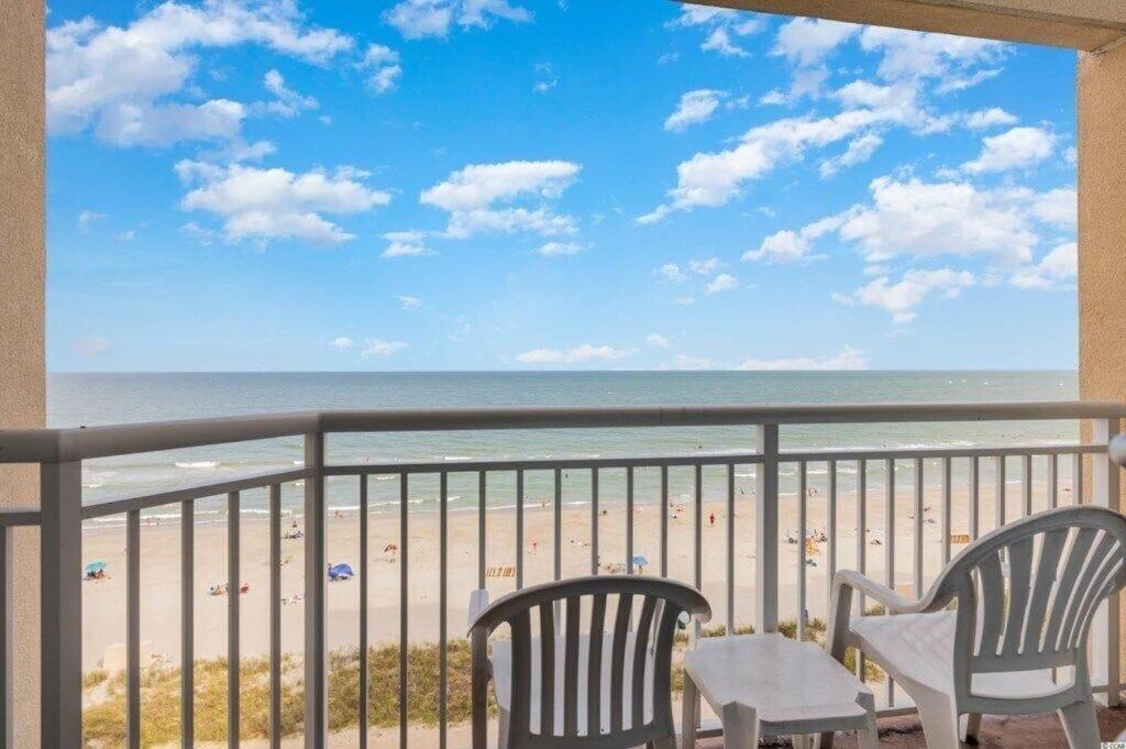 a balcony with two chairs and a view of the beach at 2501 S Ocean Blvd, 0707 - Ocean Front Sleeps 6 in Myrtle Beach