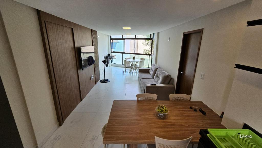 un soggiorno con un tavolo e un divano di Apartamento de luxo à beira-mar a Tamandaré