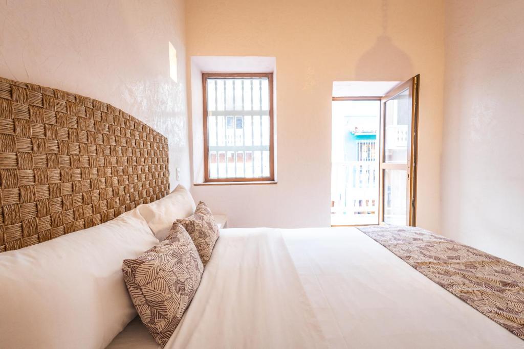 a bedroom with a white bed and a window at Casa Noa Colonial Rooms By SOHO in Cartagena de Indias