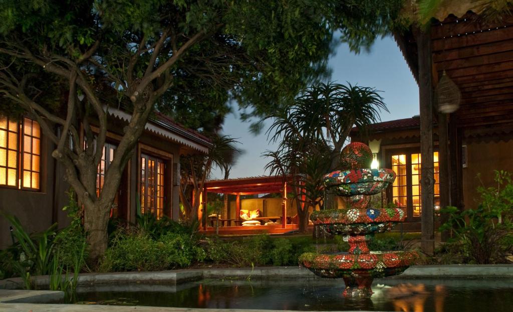 a fountain in front of a house at night at Singa Lodge - Lion Roars Hotels & Lodges in Port Elizabeth