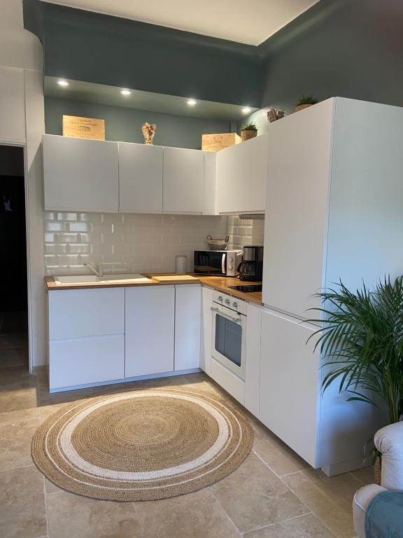 - une cuisine avec des placards blancs et un tapis dans l'établissement Bel appartement de 40m² à louer, à Nice