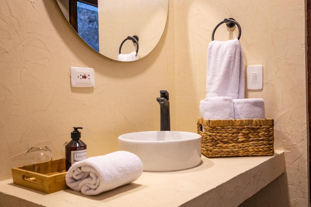 a bathroom with a sink and towels on a counter at Casa Noa Colonial Rooms By SOHO in Cartagena de Indias