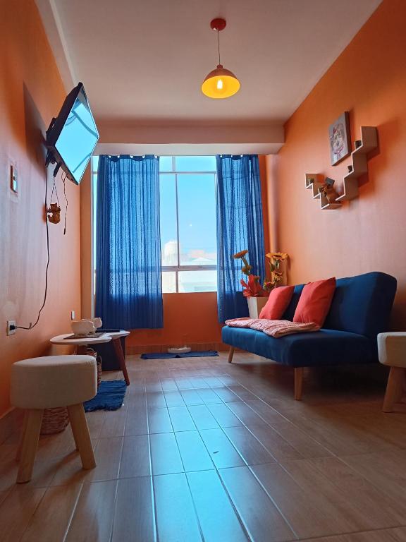 a living room with a blue couch and a tv at Departamento PET Friendly in Chancay