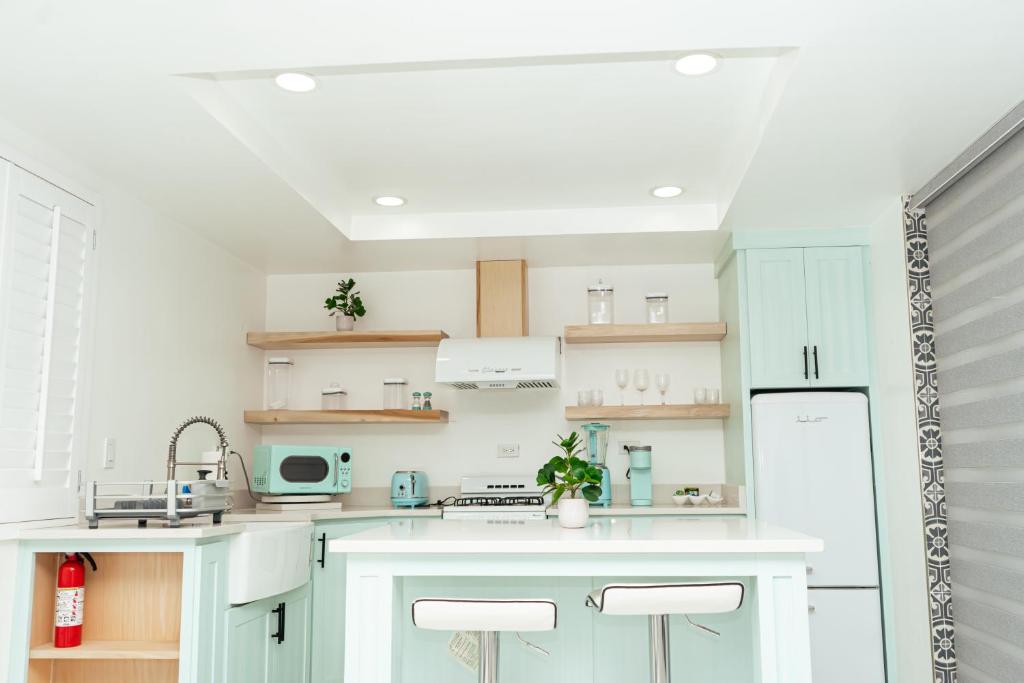 a kitchen with mint green cabinets and white appliances at Luxury Lofts With Private Pool in Ciudad Juárez