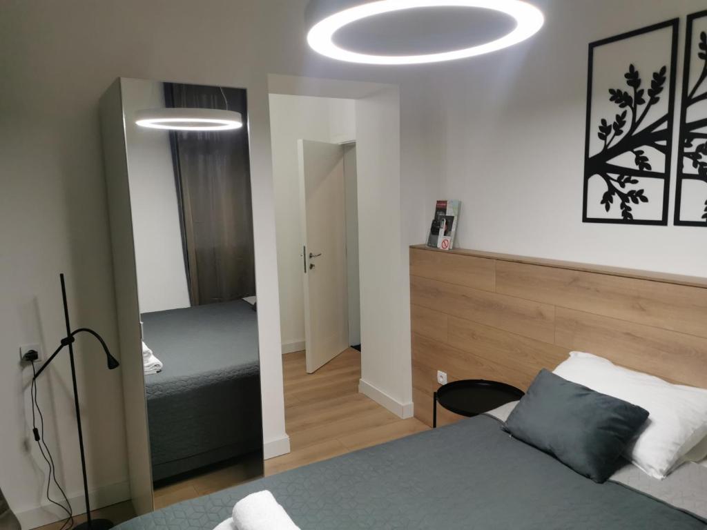 a bedroom with a bed and a room with a mirror at BG Exclusive Apartment in Belgrade