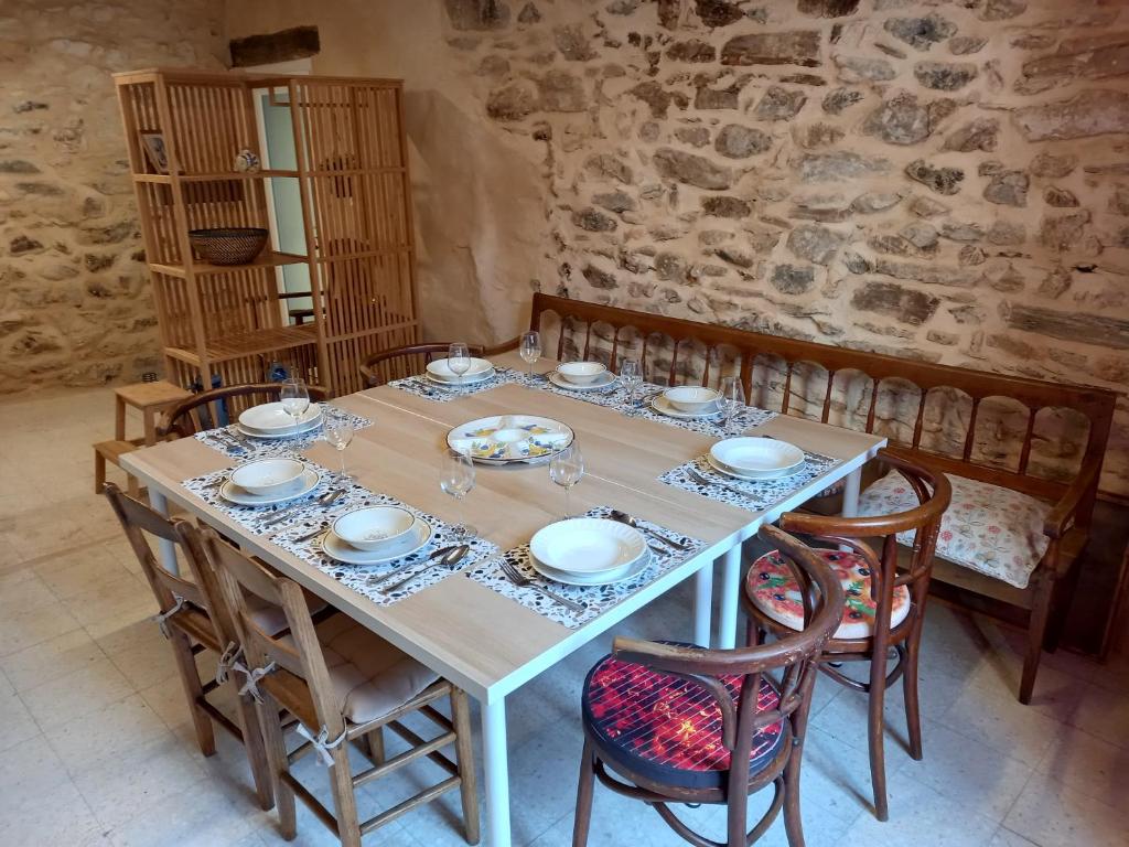 a table with chairs and plates and glasses on it at L&#39;Armandière, maison de caractère où règne calme et sérénité. in Pézenes-les-Mines