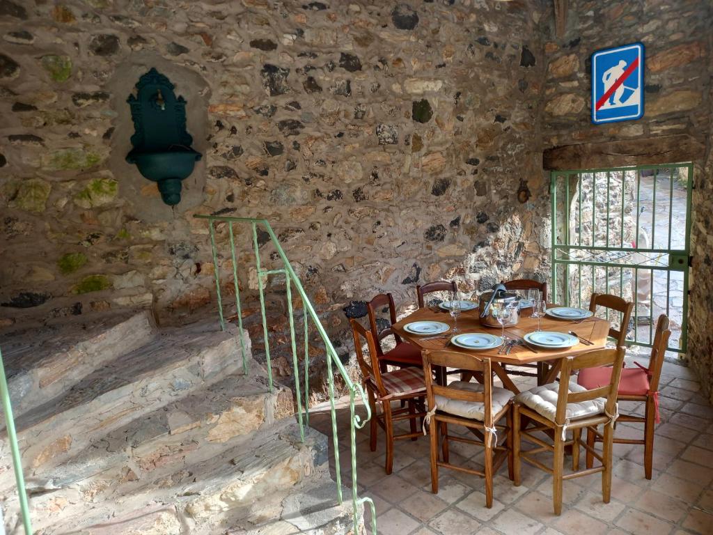 a dining room with a wooden table and chairs at L&#39;Armandière, maison de caractère où règne calme et sérénité. in Pézenes-les-Mines