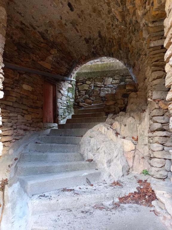 a stone tunnel with stairs and a door at L&#39;Armandière, maison de caractère où règne calme et sérénité. in Pézenes-les-Mines