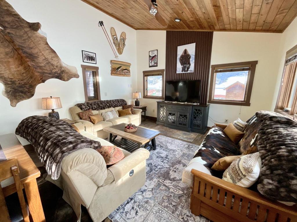 sala de estar con 2 sofás y TV en Ski Chalet, en Gallatin Gateway