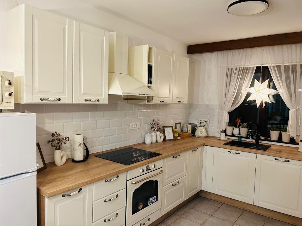 a kitchen with white cabinets and a white refrigerator at Starlight House in Bjelovar