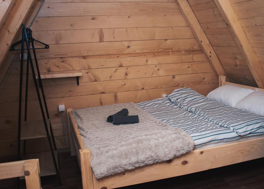 a bed in a wooden cabin with a camera on a tripod at Owl House Jelovica in Berane