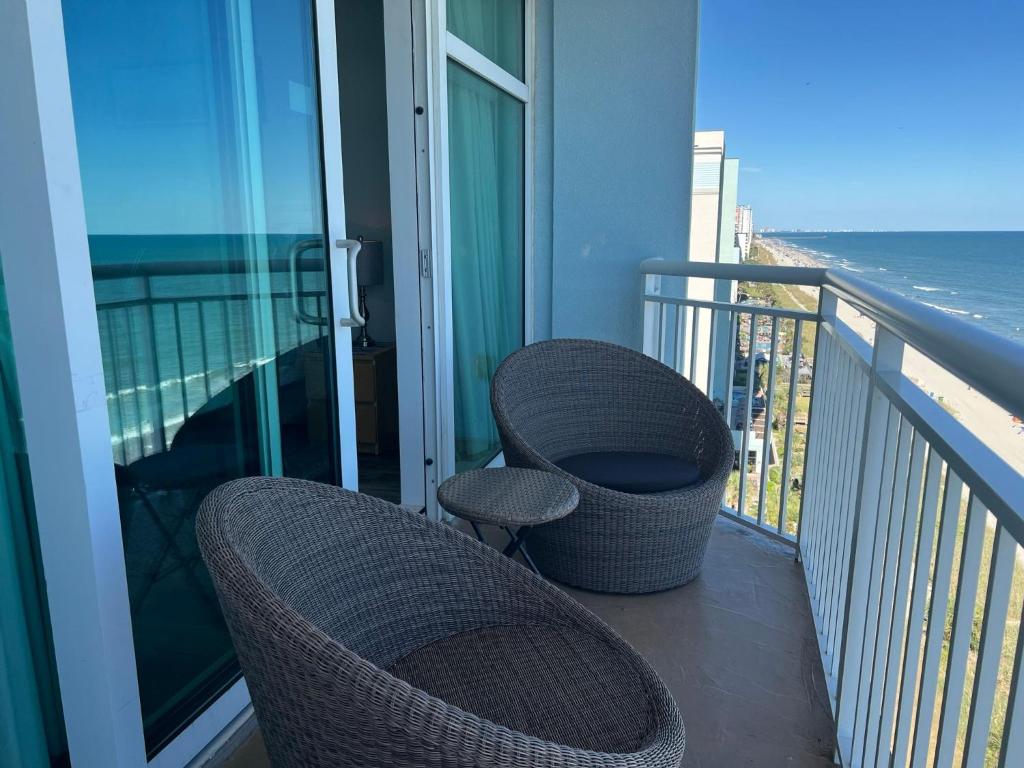 a balcony with two wicker chairs and a table at 2501 S Ocean Blvd, 1101 - Ocean Front Sleeps 8 in Myrtle Beach