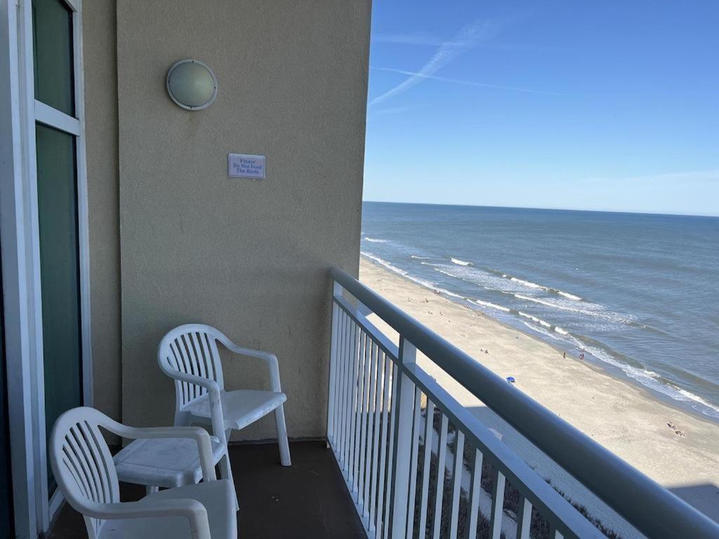 two chairs sitting on a balcony overlooking the beach at 2501 S Ocean Blvd, 1205 - Ocean Front Sleeps 6 in Myrtle Beach