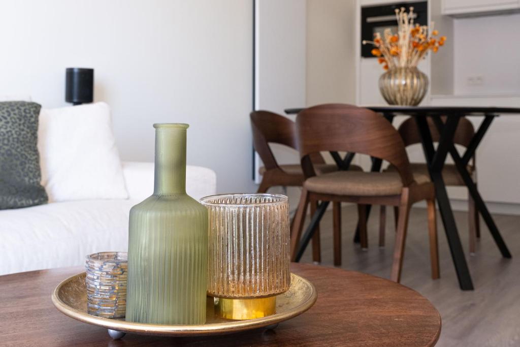 una botella y vasos en una mesa en la sala de estar en Let’s Go, en Ostende