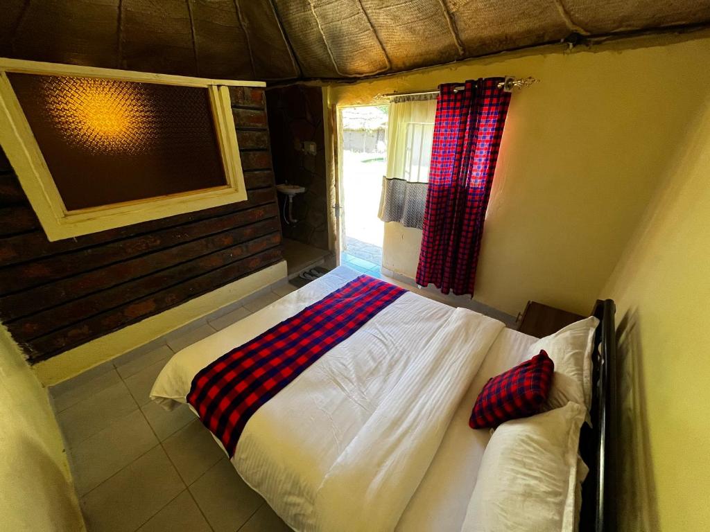 a bedroom with a bed in a room with a window at Lulunga Eco Lounge and Farm in Narok