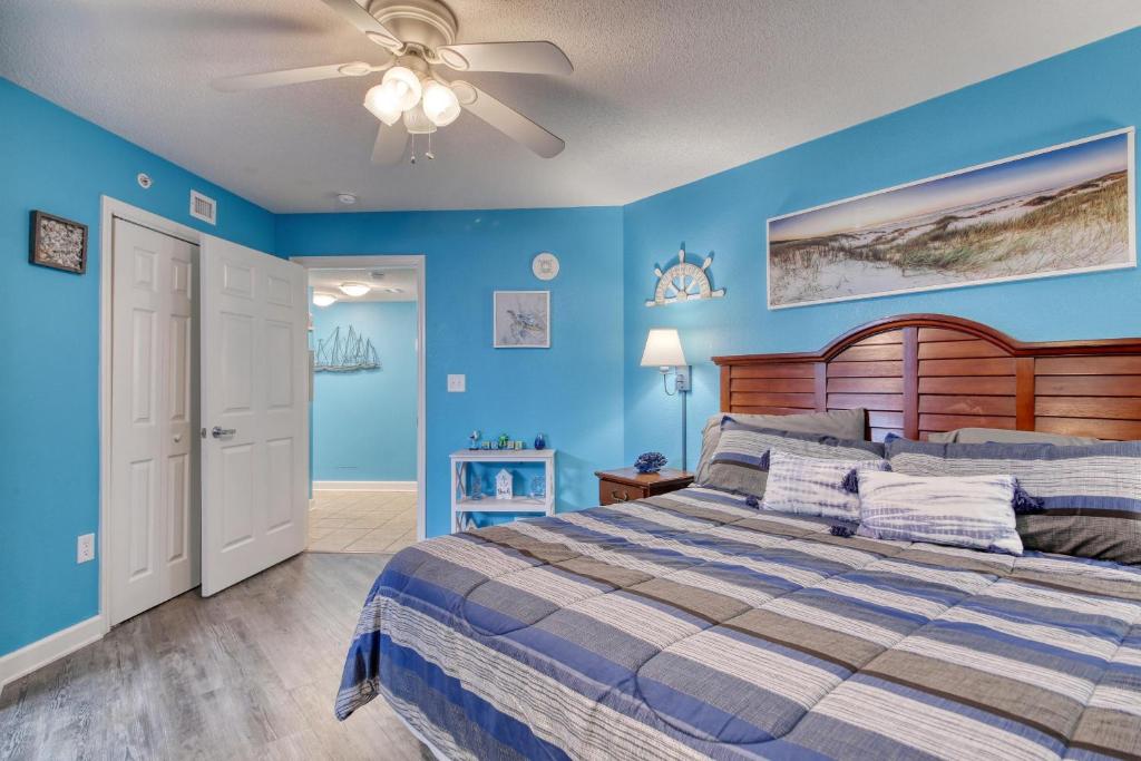 a blue bedroom with a bed and a ceiling fan at 2501 S Ocean Blvd, 0929 - Ocean View Sleeps 8 in Myrtle Beach