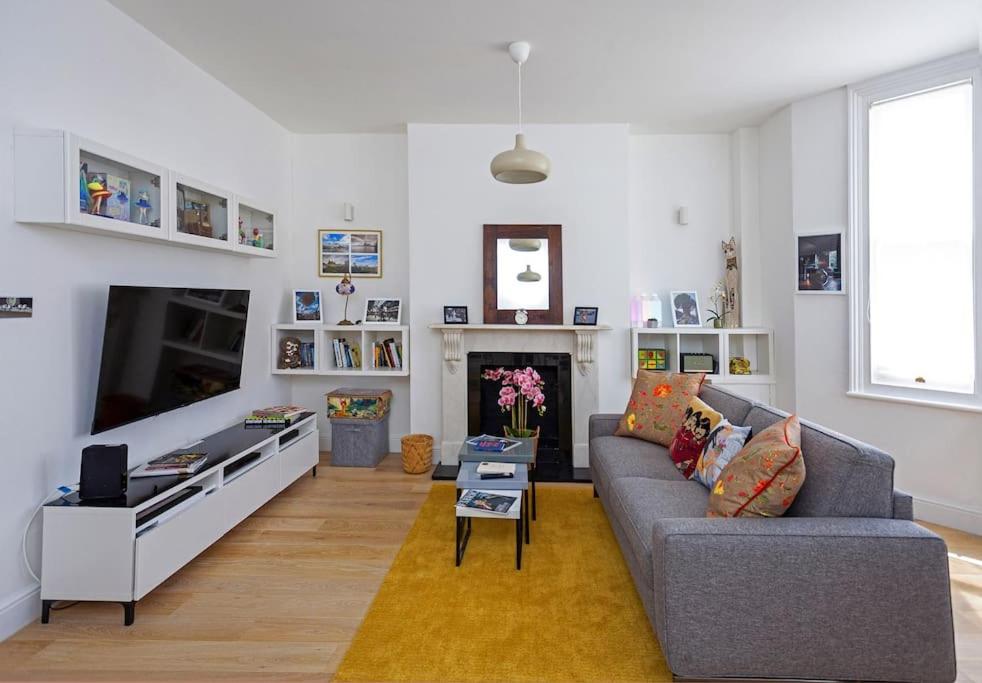 sala de estar con sofá y chimenea en Shirlock Home - Italianflat, en Londres