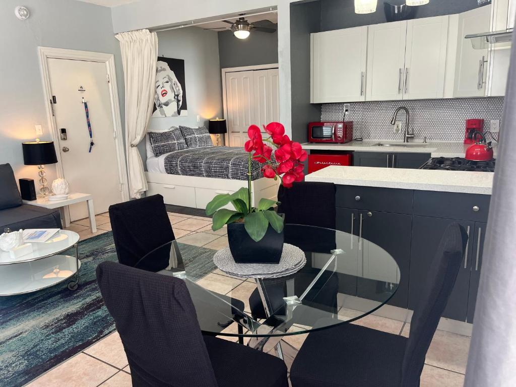 a kitchen with a glass table with a vase with red flowers at Ocean Dream in Miami Beach