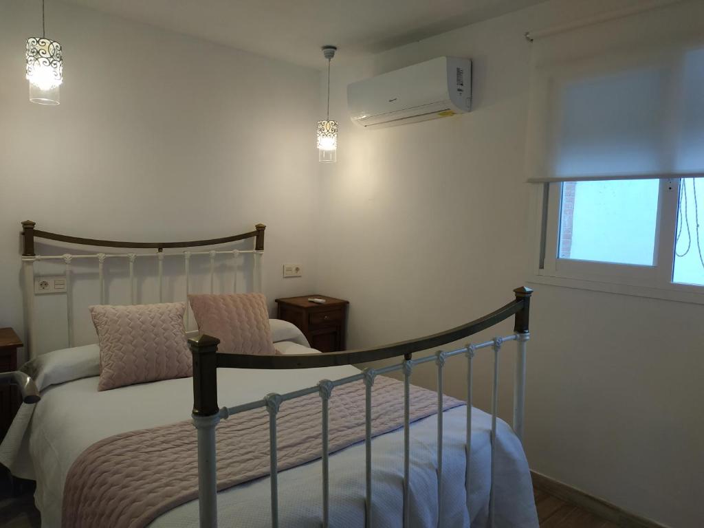 um quarto com uma cama, uma cadeira e uma janela em Casa Rural Maestros em Albanchez de Úbeda