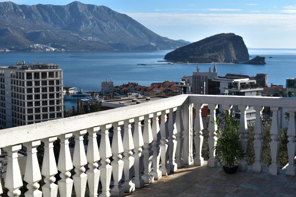 a balcony with a view of the ocean and mountains at White Hills Apartments in Budva