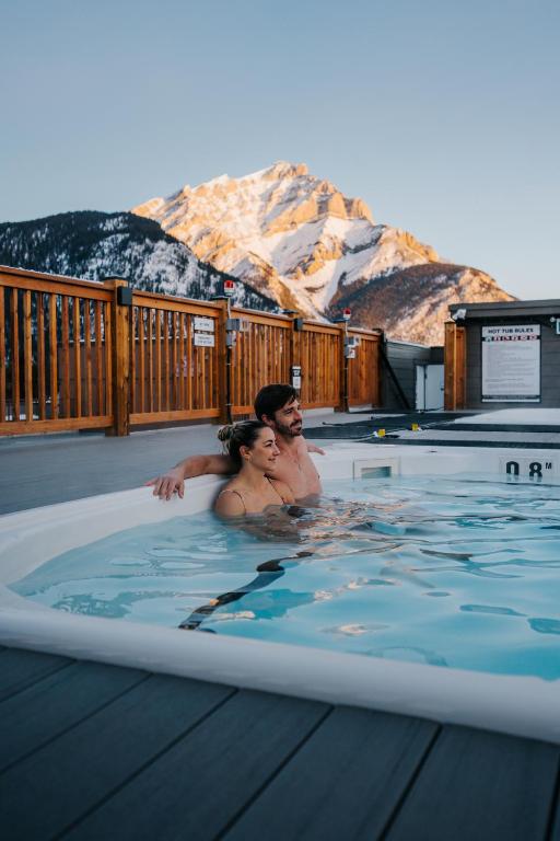 a man and a woman in a hot tub at Basecamp Suites Banff in Banff