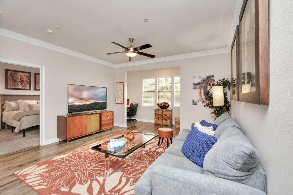 a living room with a couch and a ceiling fan at The Natural Mirage near Rice Village! in Houston
