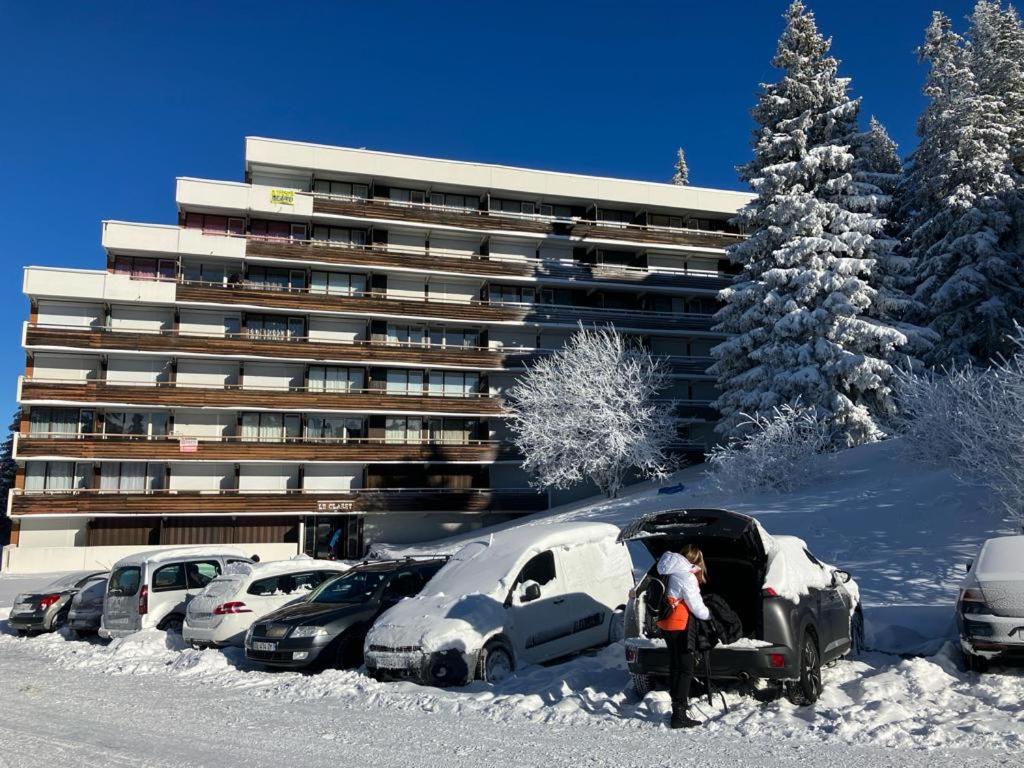 um parque de estacionamento com carros cobertos de neve em frente a um edifício em Le Flocon-Studio cabine-Balcon 4-6 Pers à 100m des pistes em Chamrousse