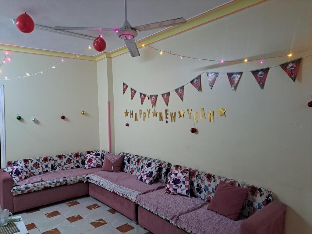 - un salon avec un canapé et des drapeaux sur le mur dans l'établissement Sweet Home- No Egyptian, à Hurghada