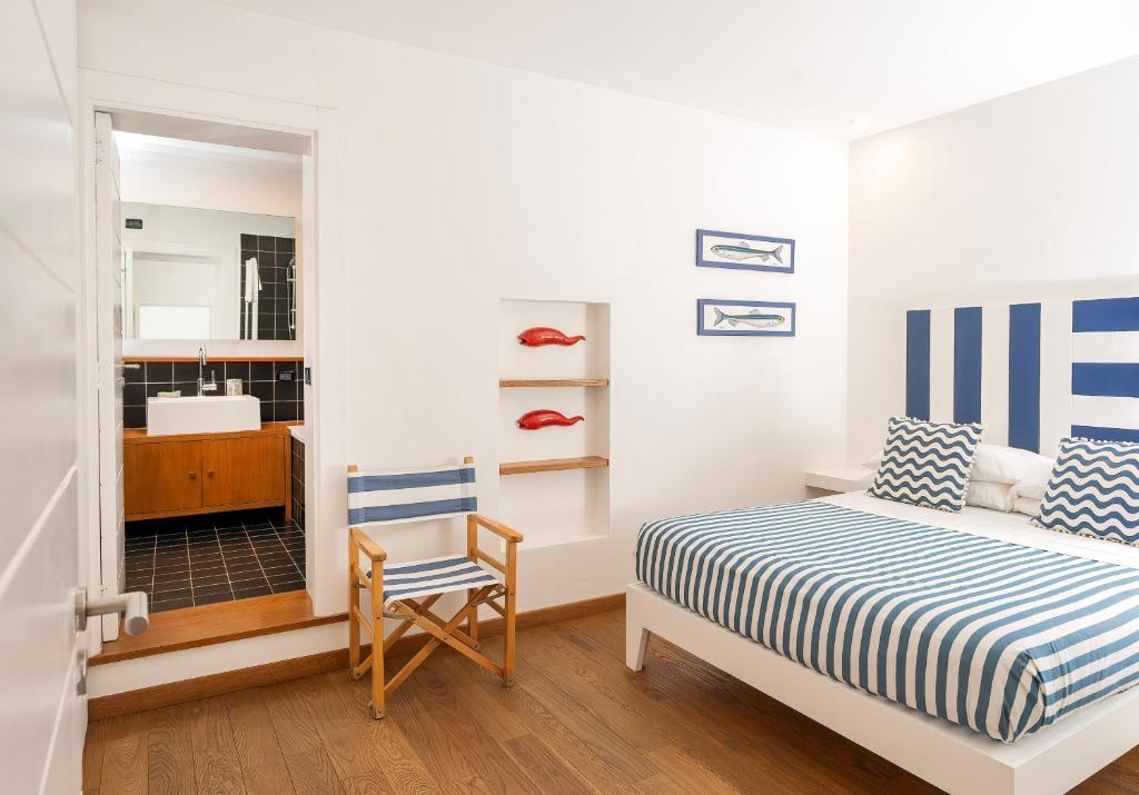 a bedroom with a bed and a chair and a mirror at Casa Zara Sorrento City Center in Sorrento